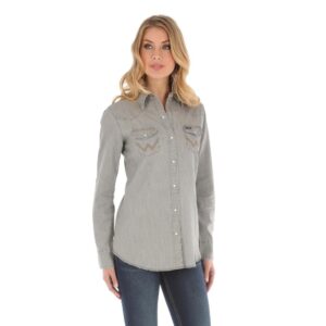 A modeled, front facing look at the Wrangler Women's Long Sleeve Western Snap W Stitching on Pocket Denim Shirt.