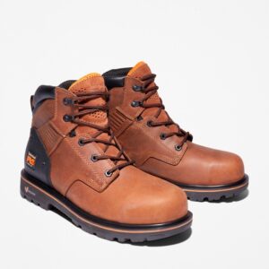 A turned pair of Timberland Ballast steel toe men's 6-inch work boots in brown with a blank background.