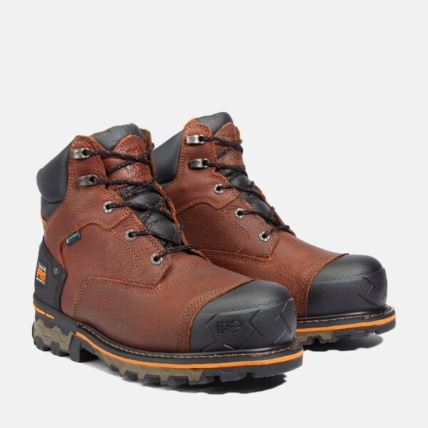 A turned pair of Timberland Boondock composite toe 6-inch waterproof insulated men's work boots in brown with a blank background.
