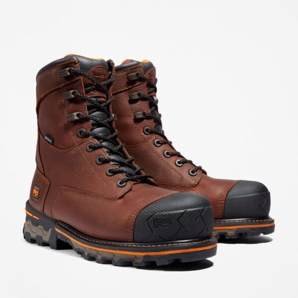 A turned pair of Timberland Boondock composite toe 8-inch waterproof men's work boots in brown with a blank background.