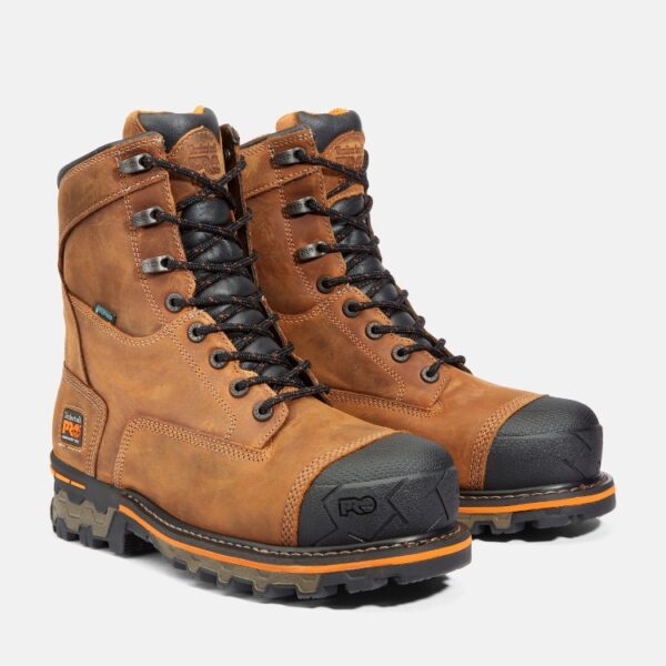 A turned pair of Timberland Boondock composite toe 8-inch waterproof men's work boots in tan with a blank background.