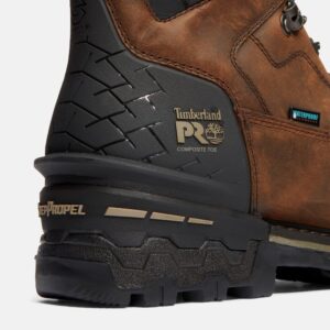 Close up of Timberland Boondock HD safety toe waterproof men's 6-inch work boot in brown showing composite toe stamp and waterproof tag with a blank background.