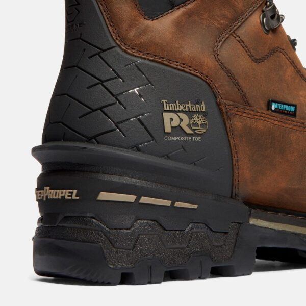 Close up of Timberland Boondock HD safety toe waterproof men's 6-inch work boot in brown showing composite toe stamp and waterproof tag with a blank background.