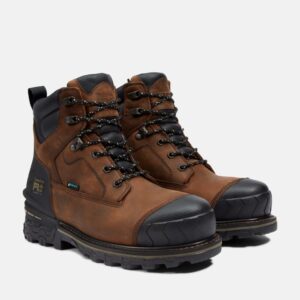 A turned pair of Timberland Boondock HD composite toe waterproof men's 6-inch work boots in brown with a blank background.