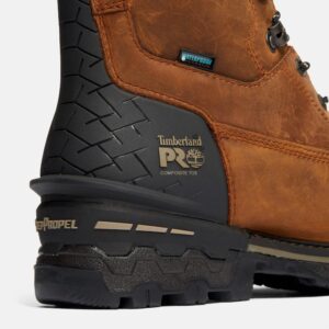 Close up of Timberland Boondock safety toe waterproof men's 8-inch work boot in brown showing composite toe stamp and waterproof tag with a blank background.