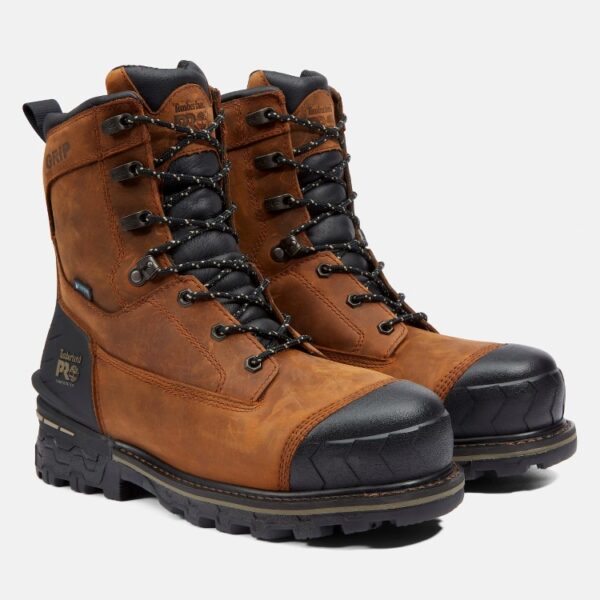 A turned pair of Timberland Boondock composite toe waterproof men's 8-inch work boots in brown with a blank background.