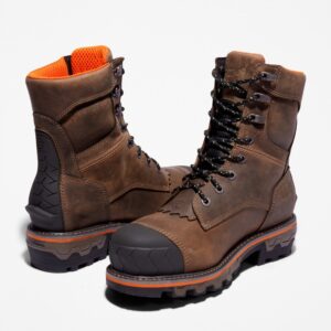 An offset pair of Timberland Boondock HD composite toe logger men's work boots in brown with a blank background.
