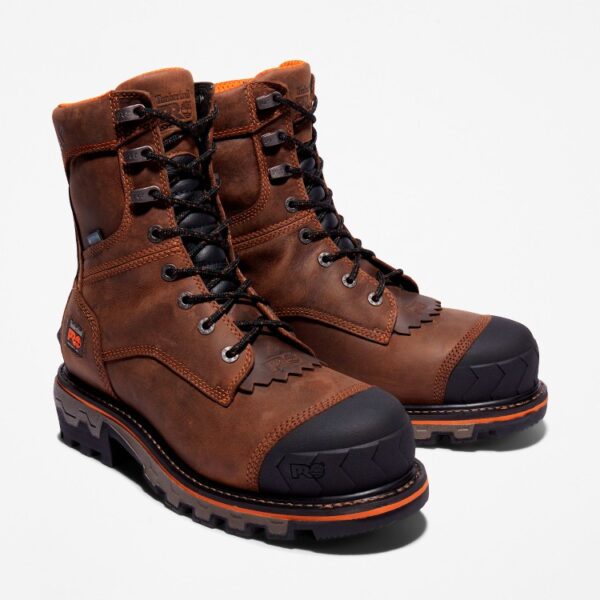 A turned pair of Timberland Boondock HD Logger composite toe waterproof men's work boots in brown with a blank background.
