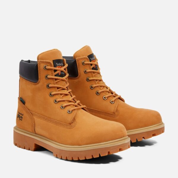 A turned pair of Timberland Direct Attach soft toe 6-inch waterproof men's work boots in wheat color with a blank background.