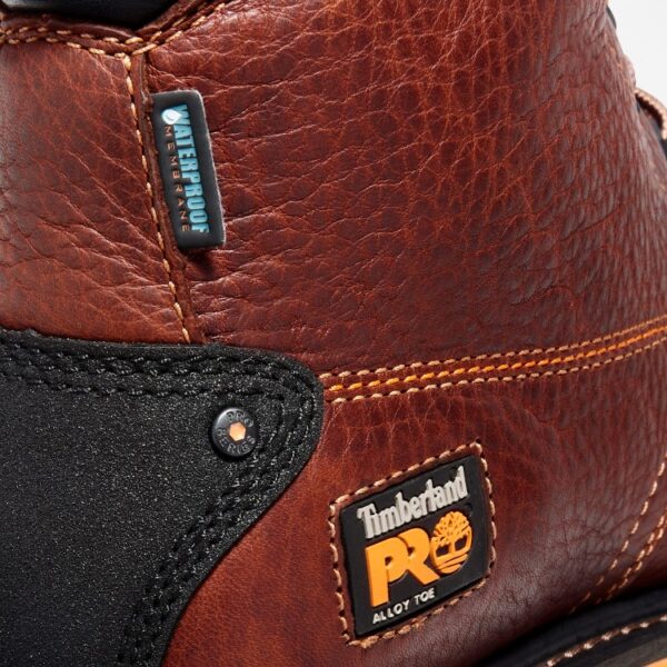 Close up of Timberland Gridworks safety toe men's 6-inch work boot in brown showing alloy toe tag with a blank background.