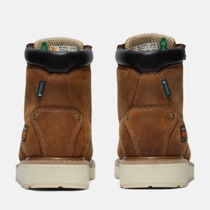 A look at the heels of a pair of Timberland Gridworks alloy toe waterproof men's 6-inch work boots in light brown with a blank background.
