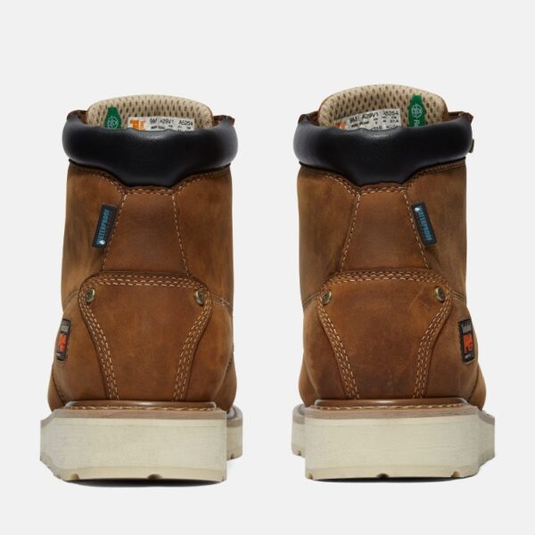 A look at the heels of a pair of Timberland Gridworks alloy toe waterproof men's 6-inch work boots in light brown with a blank background.