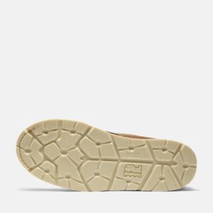 The sole of the right boot on a Timberland Gridworks alloy toe waterproof men's 6-inch work boots in light brown with a blank background.