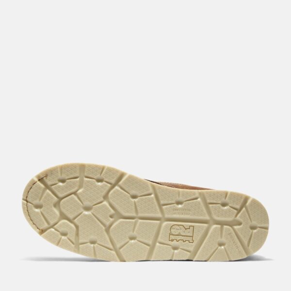 The sole of the right boot on a Timberland Gridworks alloy toe waterproof men's 6-inch work boots in light brown with a blank background.