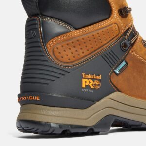 Close up of Timberland Hypercharge non-safety toe men's 6-inch work boot in tan showing soft toe stamp and waterproof tag with a blank background.