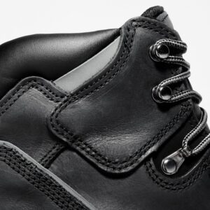 Close up of Timberland Pit Boss steel toe 6-inch men's work boot in black showing speed hooks and laces with a blank background.