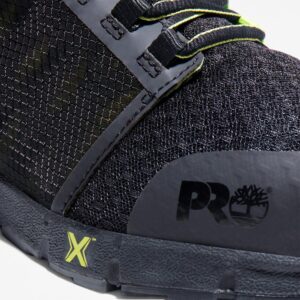 Close up of Timberland Radius composite toe men's low top work sneakers in black and green showing PRO stamp with a blank background.