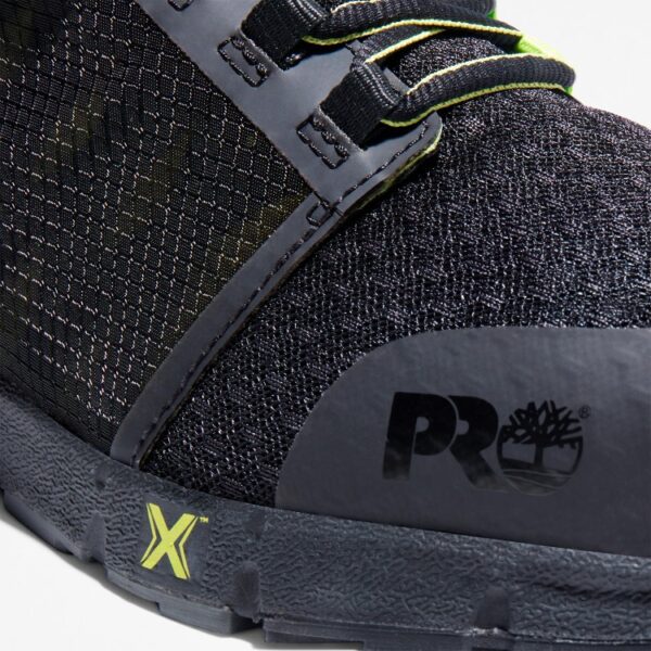 Close up of Timberland Radius composite toe men's low top work sneakers in black and green showing PRO stamp with a blank background.