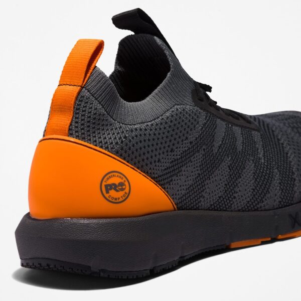 Close up of Timberland Radius composite toe men's work sneakers in gray and orange showing Timberland PRO comp toe stamp with a blank background.
