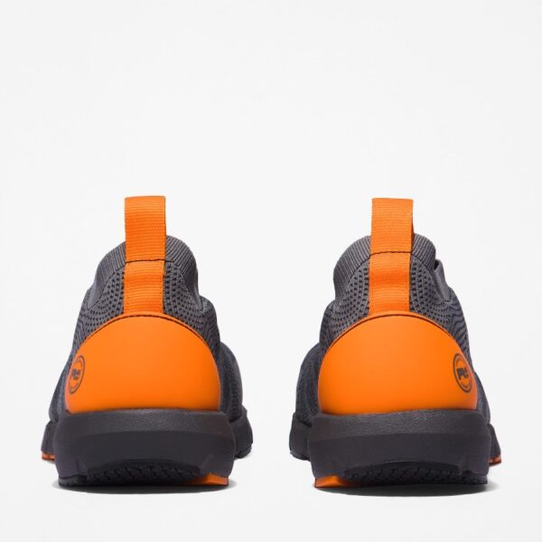 A look at the heels of a pair of Timberland Radius composite toe men's work sneakers in gray and orange with a blank background.