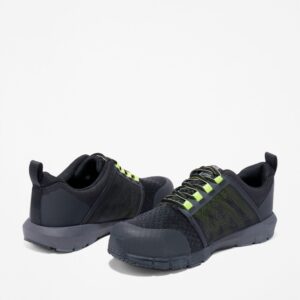 Offset pair of Timberland Radius composite toe low top men's work sneakers in black and green with a blank background.