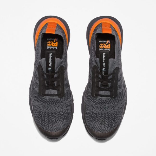 Overhead look at a pair of Timberland Radius composite toe men's work sneakers in gray and orange on a blank background.