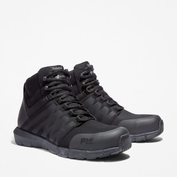 A turned pair of Timberland Radius composite toe high top men's work sneakers in black with a blank background.