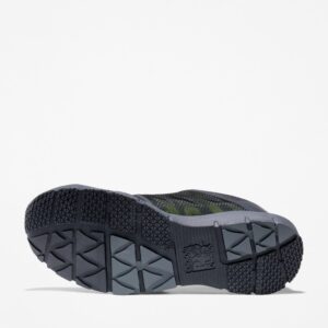 The sole of the right boot on a Timberland Radius composite toe men's low top work sneakers in black and green with a blank background.