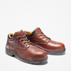 A turned pair of Timberland TiTAN casual alloy toe men's work shoes in brown with a blank background.