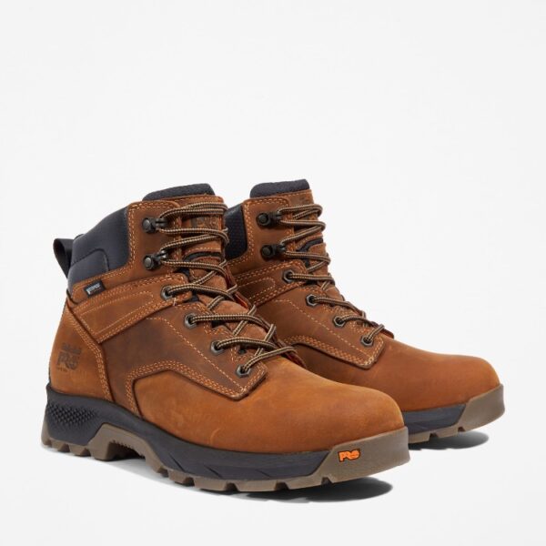 A turned pair of Timberland TiTAN EV soft toe waterproof men's 6-inch work boots in light brown with a blank background.