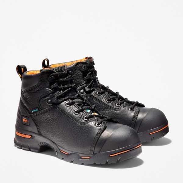 A turned pair of Timberland PRO Endurance waterproof steel toe 6-inch men's work boots in black with a blank background.