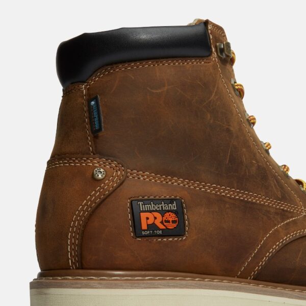 Close up of Timberland PRO Gridworks non-safety toe waterproof men's 6-inch work boot in brown showing soft toe tag with a blank background.