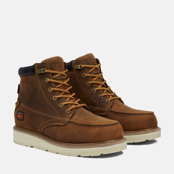 A turned pair of Timberland PRO Gridworks soft toe waterproof men's 6-inch work boots in brown with a blank background.