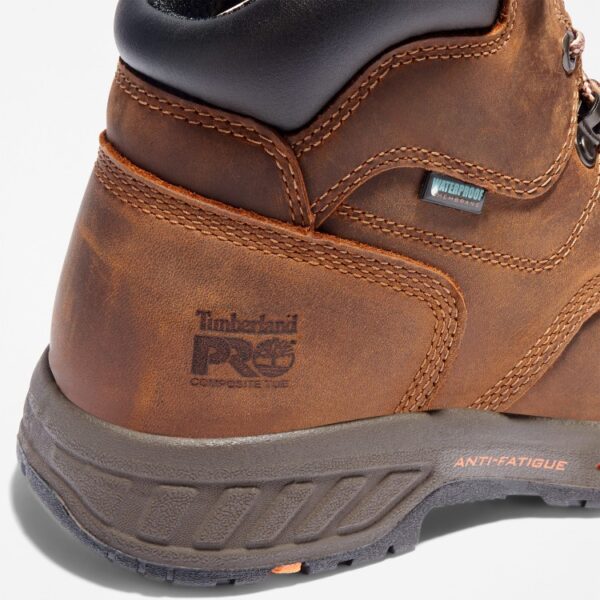 Close up of Timberland PRO Helix HD safety toe waterproof men's 6-inch work boot in brown showing composite toe stamp and waterproof tag with a blank background.
