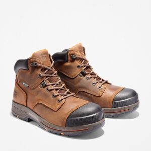 A turned pair of Timberland PRO Helix HD composite toe waterproof men's 6-inch work boots in brown with a blank background.