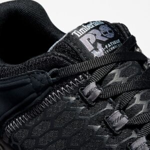 Close up of Timberland PRO Powertrain Sport alloy toe men's work sneakers in black showing anti-fatigue technology tag with a blank background.