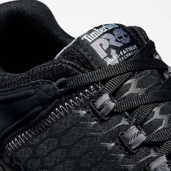 Close up of Timberland PRO Powertrain Sport alloy toe men's work sneakers in black showing anti-fatigue technology tag with a blank background.