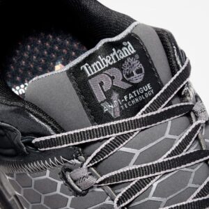 Close up of Timberland PRO Powertrain Sport alloy toe men's work sneakers in gray and black showing anti-fatigue technology tag with a blank background.