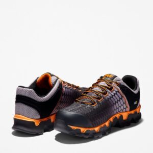 Offset pair of Timberland PRO Powertrain Sport alloy toe men's work sneakers in orange and black with a blank background.