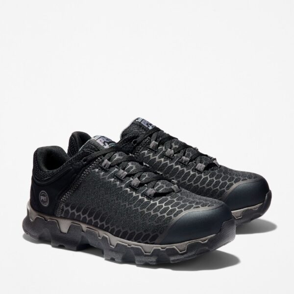 A turned pair of Timberland PRO Powertrain Sport alloy toe men's work sneakers in black with a blank background.