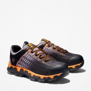 A turned pair of Timberland PRO Powertrain Sport alloy toe men's work sneakers in orange and black with a blank background.