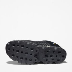 The sole of the right boot on a Timberland PRO Powertrain Sport alloy toe men's work sneakers in black with a blank background.