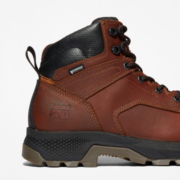Close up of Timberland TiTAN EV safety toe men's 6-inch waterproof work boot in brown showing composite toe stamp with a blank background.