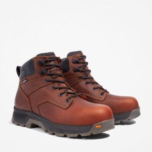 A turned pair of Timberland TiTAN EV composite toe waterproof men's 6-inch work boots in brown with a blank background.