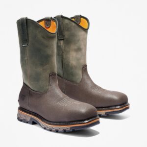 A turned pair of Timberland True Grit composite toe waterproof men's pull-on work boots in brown and green with a blank background.