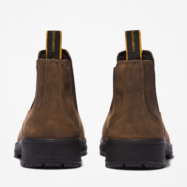 A look at the heels of a pair of Timberland Nashoba Casual composite toe men's Chelsea work boots in brown with a blank background.