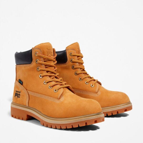 A turned pair of Timberland Direct Attach steel toe waterproof insulated women's 6-inch work boots in wheat with a blank background.