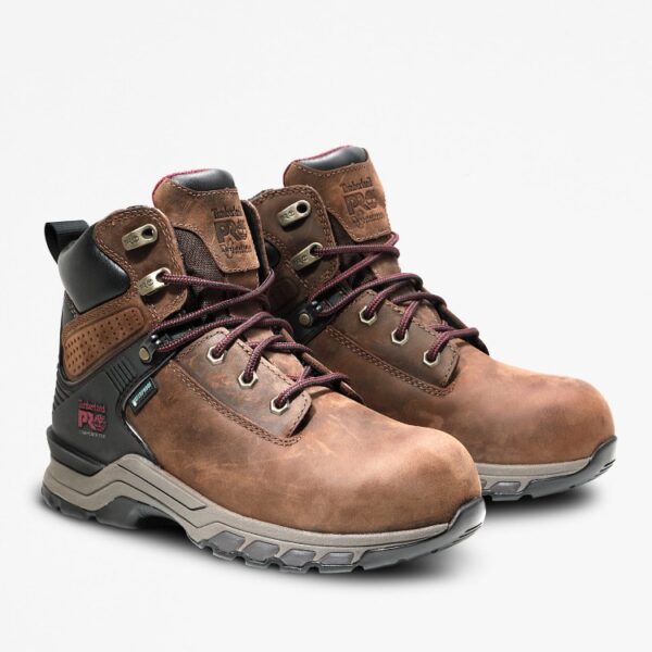 A turned pair of Timberland Hypercharge composite toe waterproof women's logger work boots in brown with a blank background.