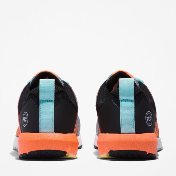 A look at the heels of a pair of Timberland Radius composite toe women's work sneakers in gray, orange, black, and light blue with a blank background.