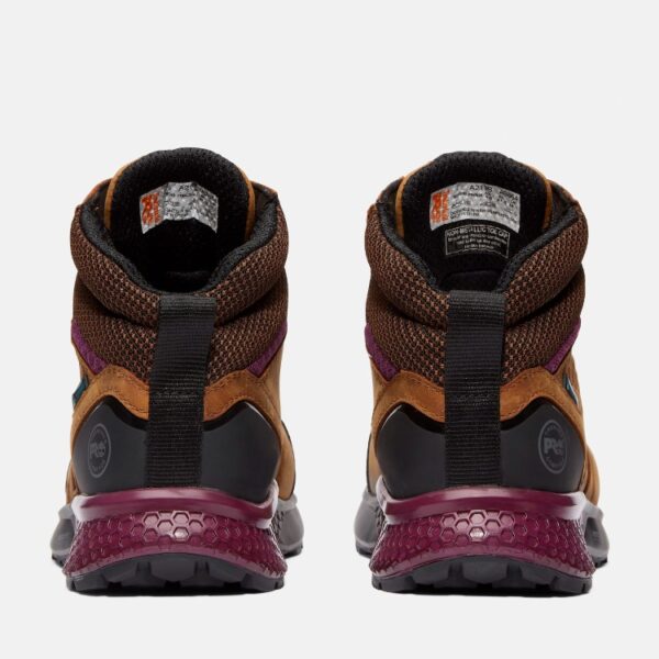 A look at the heels of a pair of Timberland Reaxion composite toe waterproof women's work sneakers in tan and purple with a blank background.